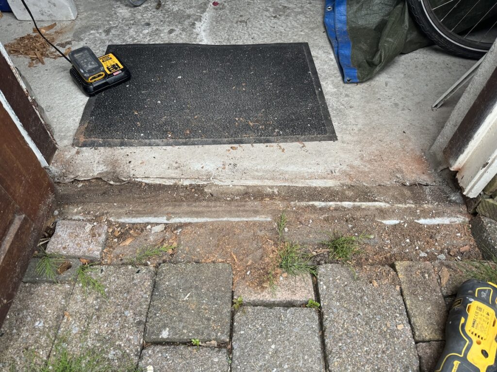 Houtrot in onderdorpel van schuurdeur vóór herstel in Lelystad