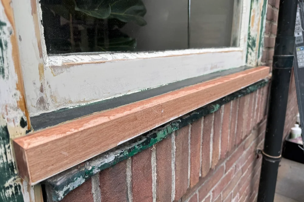 Herstelde onderdorpel en raamkozijn na houtrotreparatie
