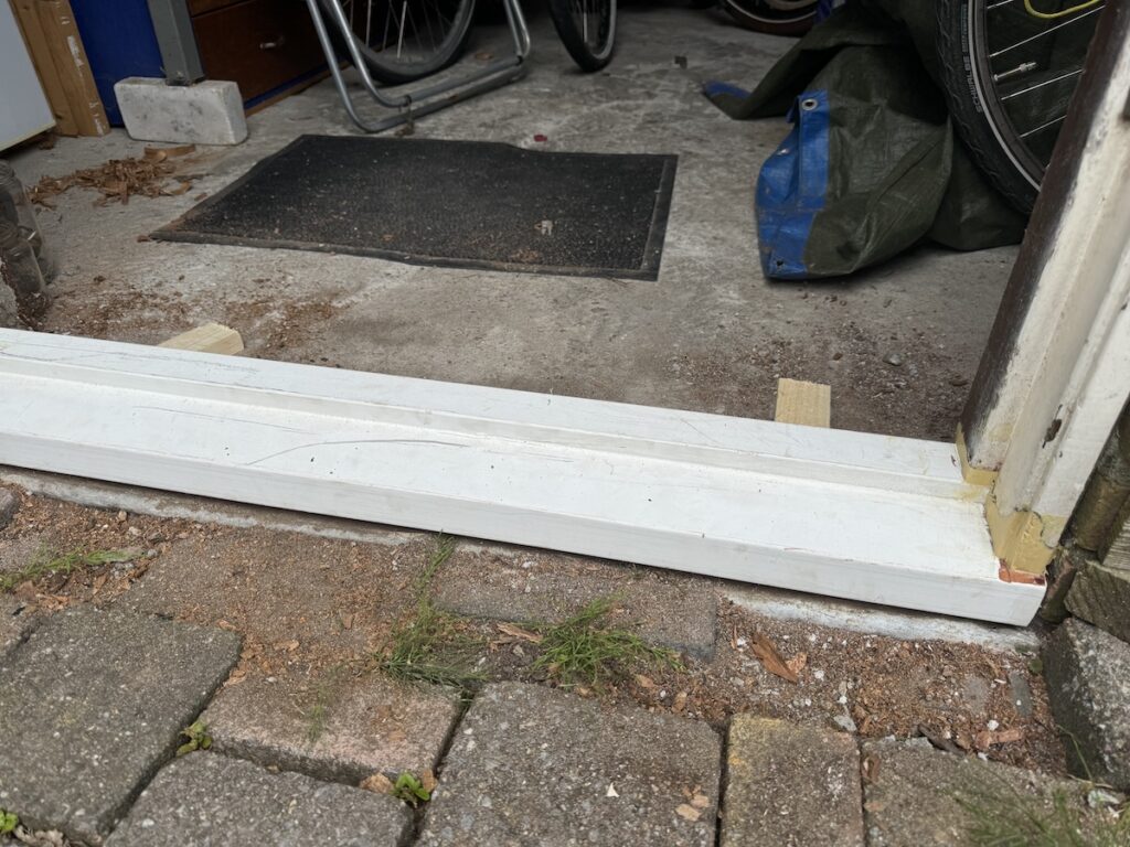 Herstelde onderdorpel bij schuurdeur na houtreparatie in Lelystad